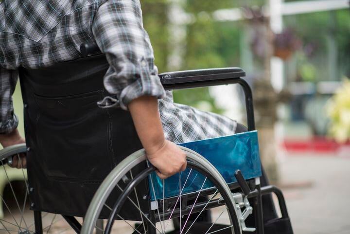 close-up-senior-woman-hand-wheel-wheelchair-during-walk-hospital-1
